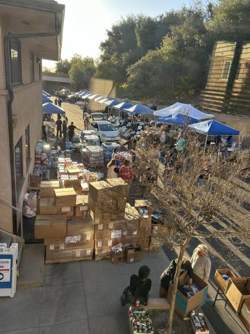 The distribution at SCC was originally planned for indoors but quickly moved outdoors due to the incredible amount of donations received. Volunteers collaborated to place items in trunks of cars as people drove through.