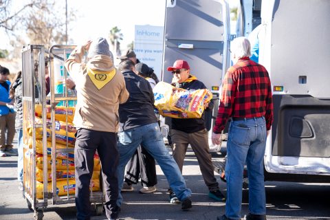 Volunteers at the SCC distribution stack pet food donated by Walmart.