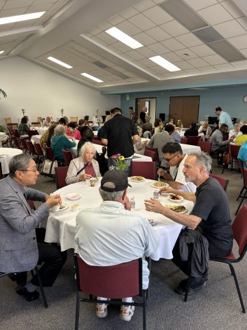 Santa Monica interim Pastor Andrew Pak (left) talks with guests during the luncheon.