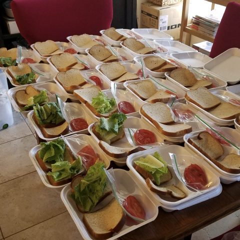 Sandwiches are assembled with turkey, cheese, lettuce, tomato, cucumber, and packaged mustard and mayonnaise.