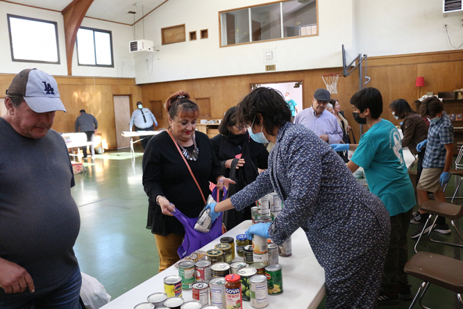 Visitors choose from a variety of items in the food pantry located in Whittier church gym.